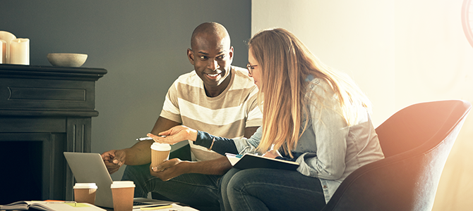 A guy and a girl discuss something while looking at a laptop.