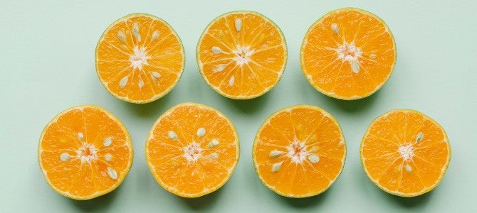 Vitamin C+Zinc Article_In-Article Image 01 orange halves laid on mint green background